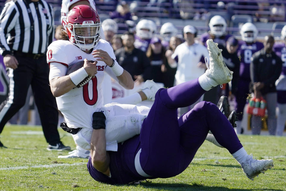 Northwestern defensive tackle Trevor Kent, bottom, tackles Rutgers quarterback Noah Vedral during the second half of an NCAA college football game in Evanston, Ill., Saturday, Oct. 16, 2021. Northwestern won 21-7. (AP Photo/Nam Y. Huh)