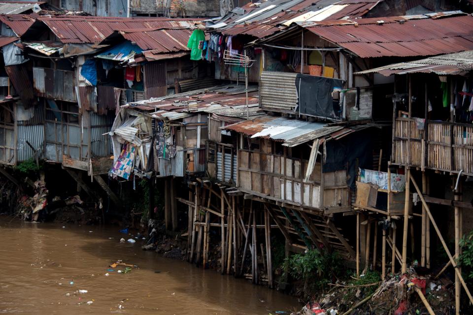 <p>Shanties with hanging toilets, and waste that runs straight into the river below, Jakarta, Indonesia. (Photo: Bay Ismoyo/AFP/Getty Images) </p>