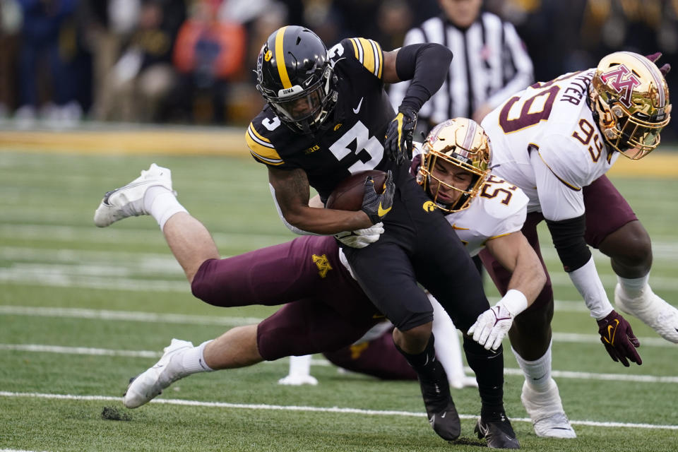 Iowa wide receiver Tyrone Tracy Jr. (3) tries to break a tackle by Minnesota linebacker Mariano Sori-Marin (55) during the first half of an NCAA college football game, Saturday, Nov. 13, 2021, in Iowa City, Iowa. (AP Photo/Charlie Neibergall)