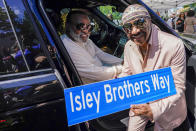 Ron Isley, left, and Ernie Isley pose for a photo with the street sign dedicated to them during a street renaming ceremony, Thursday, June 24, 2021, in Teaneck, N.J. Two New Jersey towns have renamed streets in honor of the Isley Brothers, the legendary R&B group behind songs such as, "Shout," "Twist and Shout" and "It's Your Thing." Ron Isley and Ernie Isley attended separate ceremonies Thursday in Teaneck and Englewood, neighboring towns outside New York City where they lived during the band's heyday in the 1960s. (AP Photo/Mary Altaffer)