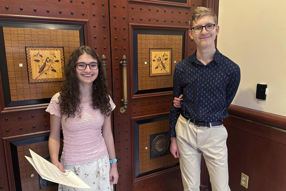 Sue Katherine Boye Williams, 16, a junior at the Watkinson School in Hartford, Conn. and Chris Tracy, 19, a senior at the school, stand near an inlaid design of Connecticut's current State Insect, the European "Praying" Mantis, on the door to a hearing room at Connecticut's Legislative Office Building in Hartford on March 8, 2024. Both testified before a legislative committee, urging lawmakers to replace the non-native praying mantis with the native Spring Azure Butterfly. (AP Photo/Susan Haigh)