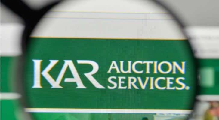 A magnifying glass zooms in on the website of KAR Auction Services (KAR).