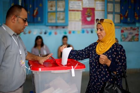 Woman casts her vote in a polling station during presidential election in Tunis