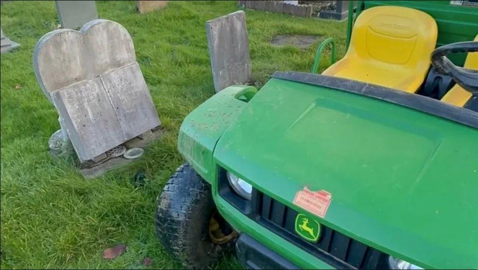 A small vehicle appearing to be parked next to two headstones at the Gloucestershire cemetery (Alastair Chambers)