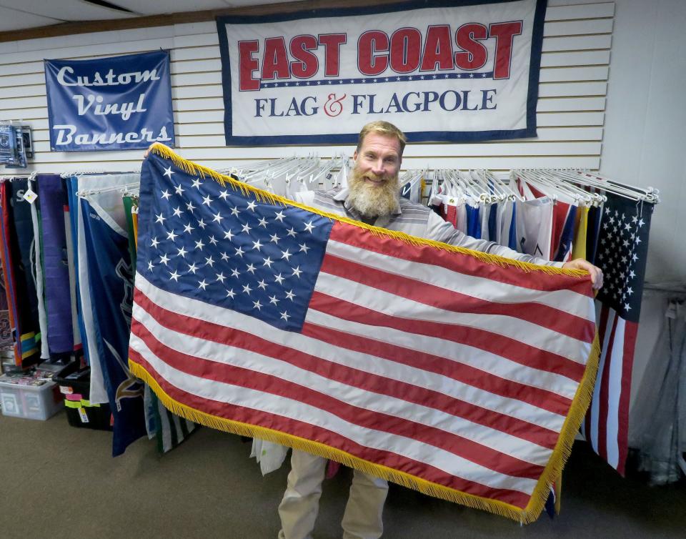 East Coast Flag & Flagpole owner Jim Kuhl holds an American flag in the Beachwood store Monday, October 24, 2022.  The 26-year-old shop on Route 9 provides flags, flagpoles, installation, and service.