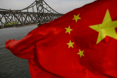 FILE PHOTO: A Chinese flag is seen in front of the Friendship bridge over the Yalu River connecting the North Korean town of Sinuiju and Dandong in China's Liaoning Province on April 1, 2017. REUTERS/Damir Sagolj/File Photo