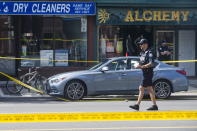 <p>Police are photographed investigating a car with a bullet hole within the scene of a mass shooting in Toronto on July 23, 2018. (Photo: Christopher Katsarov/The Canadian Press via AP) </p>