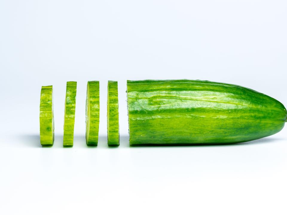 Half of a cucumber with a portion sliced.