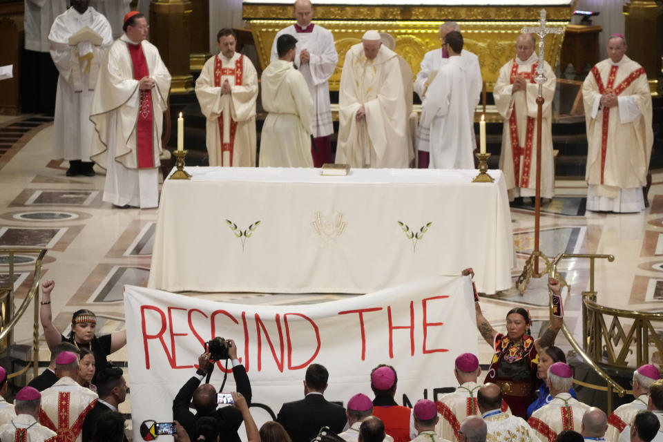 People displays a banner during Pope Francis mass at the National Shrine of Saint Anne de Beaupré in Quebec City, Canada, Thursday, July 28, 2022. Pope Francis celebrates Mass in Quebec and gives marching orders to the country's priests, deacons and religious sisters. (AP Photo/Gregorio Borgia)