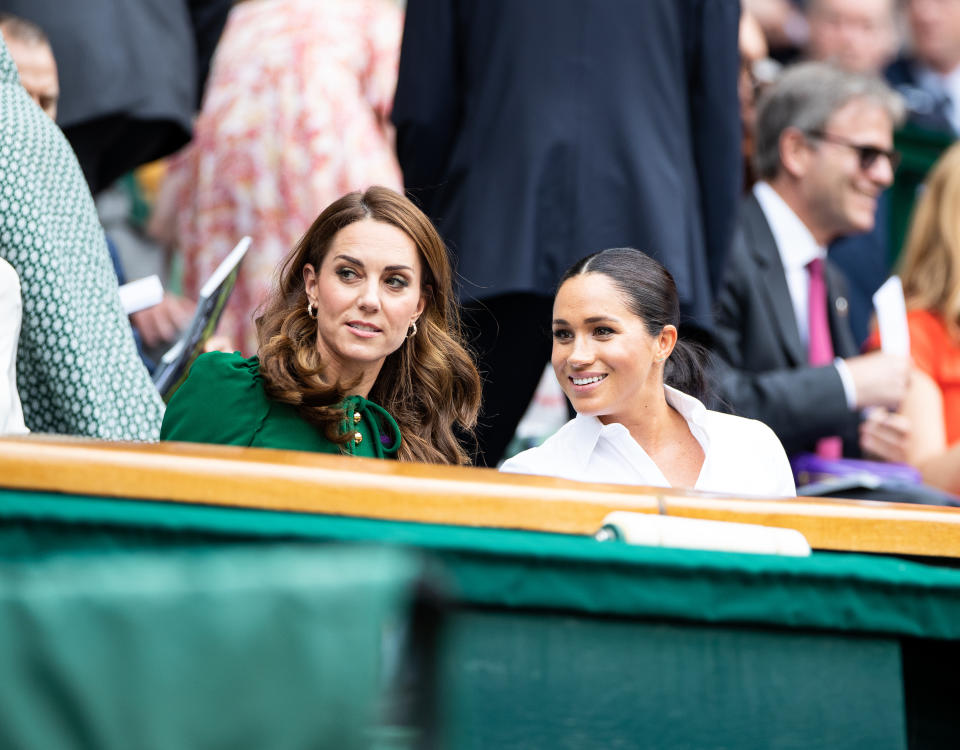 LONDON, ENGLAND - JULY 13: Catherine, Duchess of Cambridge talks with Meghan, Duchess of Sussex in the royal box before the start of the Women's Singles Final between Simona Halep of Romania and Serena Williams of USA (not pictured) at The Wimbledon Lawn Tennis Championship at the All England Lawn and Tennis Club at Wimbledon on July 13, 2019 in London, England. (Photo by Simon Bruty/Anychance/Getty Images)