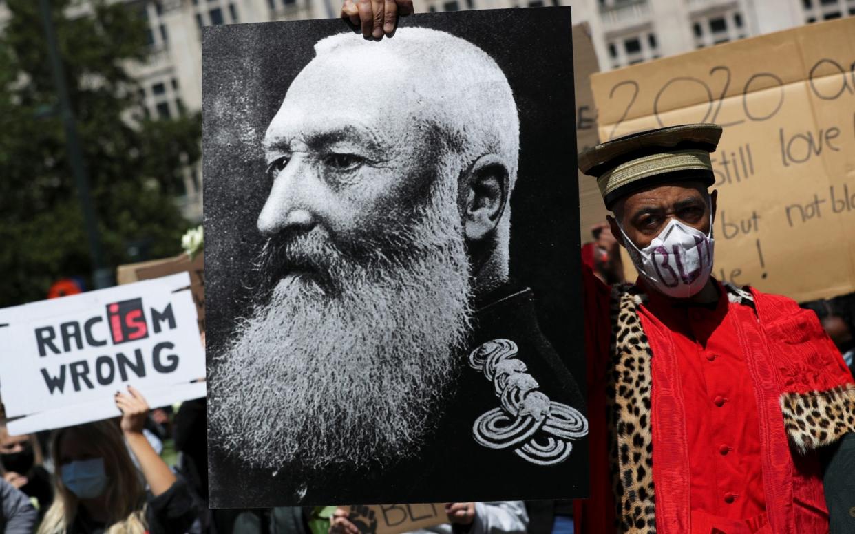 A Black Lives Matter protester holds a portrait of Leopold II at a demonstration in Brussels this month. - Yves Herman/Reuters