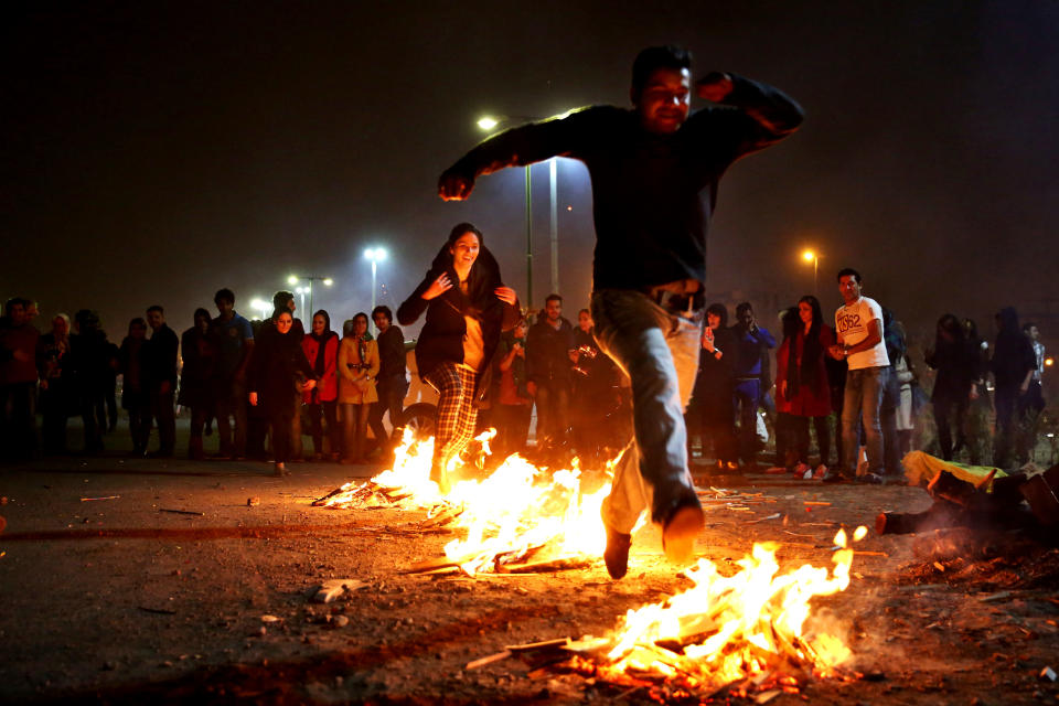 In this picture taken on Tuesday, March 18, 2014, Iranians jump over bonfires during a celebration, known as “Chaharshanbe Souri,” or Wednesday Feast, marking the eve of the last Wednesday of the solar Persian year, in Pardisan park, Tehran, Iran. The festival has been frowned upon by hard-liners since the 1979 Islamic revolution because they consider it a symbol of Zoroastrianism, one of Iran’s ancient religions of Iranians. They say it goes against Islamic traditions. (AP Photo/Ebrahim Noroozi)