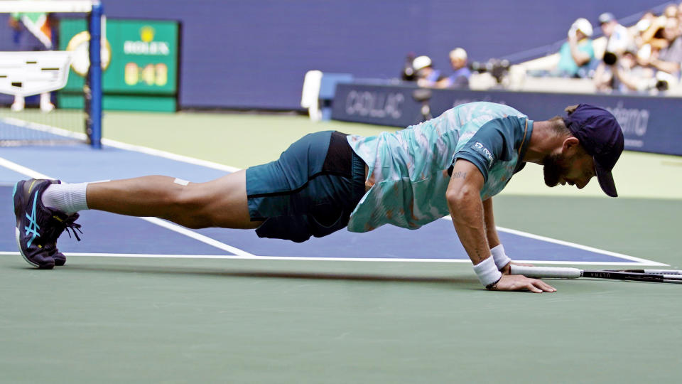 Corentin Moutet, of France, does push ups on the court after missing a return to Casper Ruud, of Norway, during the fourth round of the U.S. Open tennis championships, Sunday, Sept. 4, 2022, in New York. (AP Photo/Eduardo Munoz Alvarez)
