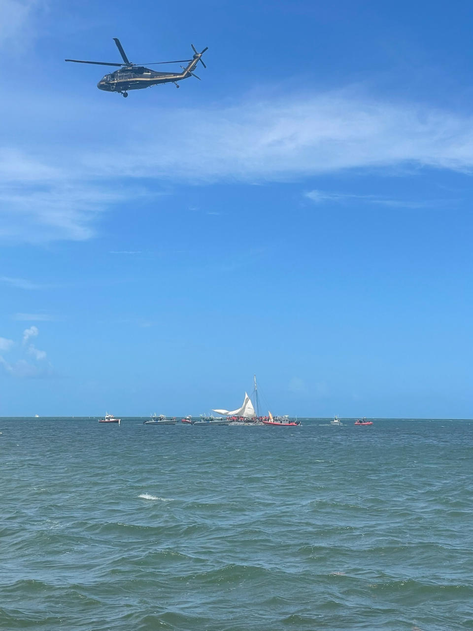 In this image posted on the USCGSoutheast Twitter page, rescue crews safely transfer people from a grounded vessel believed to be carrying migrants, to U.S. Coast Guard ships, Saturday, Aug. 6, 2022, off the coast of Key Largo, Fla., near the gated community of Ocean Reef. (Courtesy of U.S. Coast Guard via AP)