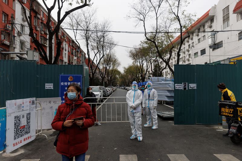 FILE PHOTO: Epidemic-prevention workers in protective suits stand guard at a residential compound as COVID-19 outbreaks continue in Beijing