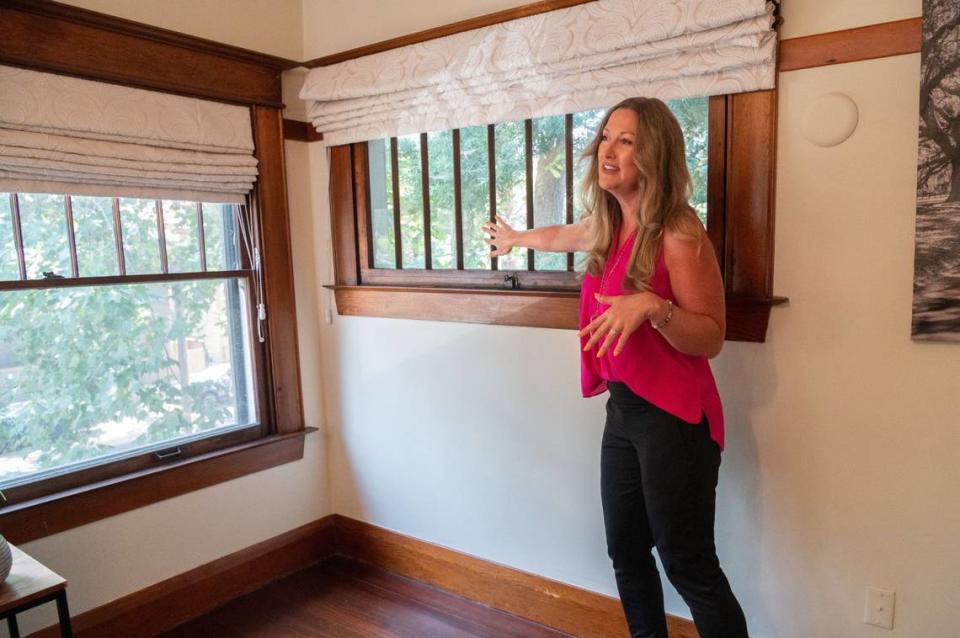 Emily Valdez with EXP Realty points to the windows in an upstairs bedroom of the historic Wilder House in Sacramento’s Alkali Flat neighborhood on Monday. Valdez said the windows are made from wavy glass.