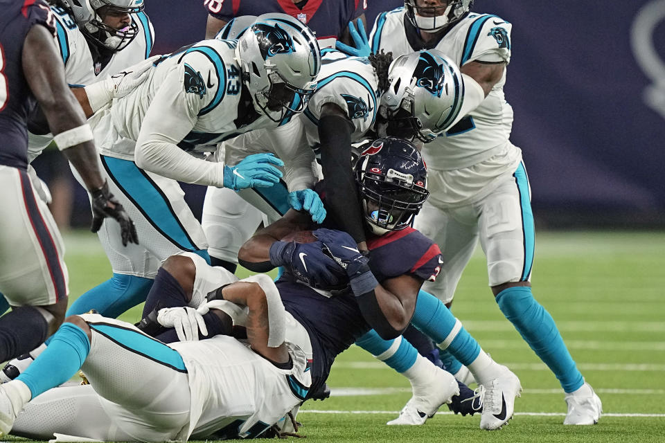 Houston Texans running back Mark Ingram II (2) is wrapped up by Carolina Panthers' Shaq Thompson (7), Haason Reddick (43) and Jaycee Horn during the second half of an NFL football game Thursday, Sept. 23, 2021, in Houston. (AP Photo/Eric Christian Smith)