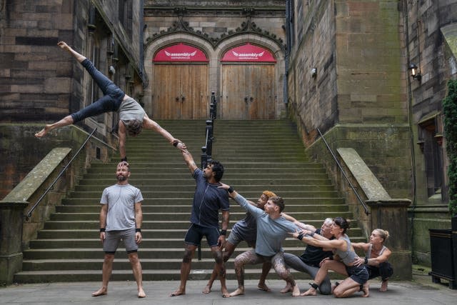 A group of acrobats perform in front of some steps