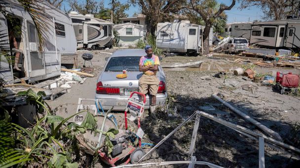 PHOTO: Sean Hunt sings on the trunk of his damaged car in front of his camper in the aftermath of Hurricane Ian in Fort Myers, Fla., Sept. 29, 2022. (Ricardo Arduengo/AFP via Getty Images)