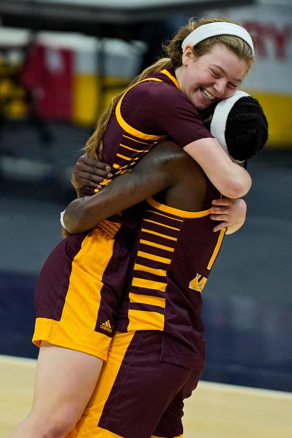 Central Michigan's Molly Davis, left, is hugged by Micaela Kelly after CMU defeated Bowling Green, 77-72, in the championship of the Mid-American Conference tournament on Saturday, March 13, 2021, in Cleveland.