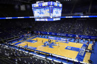 Morehead State and Kentucky players jump for the opening tip in front of a socially distanced crowd mixed with cardboard cutouts, at an NCAA college basketball game in Lexington, Ky., Wednesday, Nov. 25, 2020. (AP Photo/James Crisp)