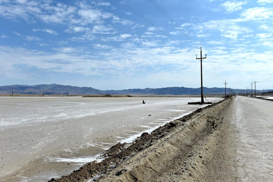 A dirt road runs next to a lithium evaporation pod, left, owned by Albemarle Corporation in Silver Peak, Nevada.