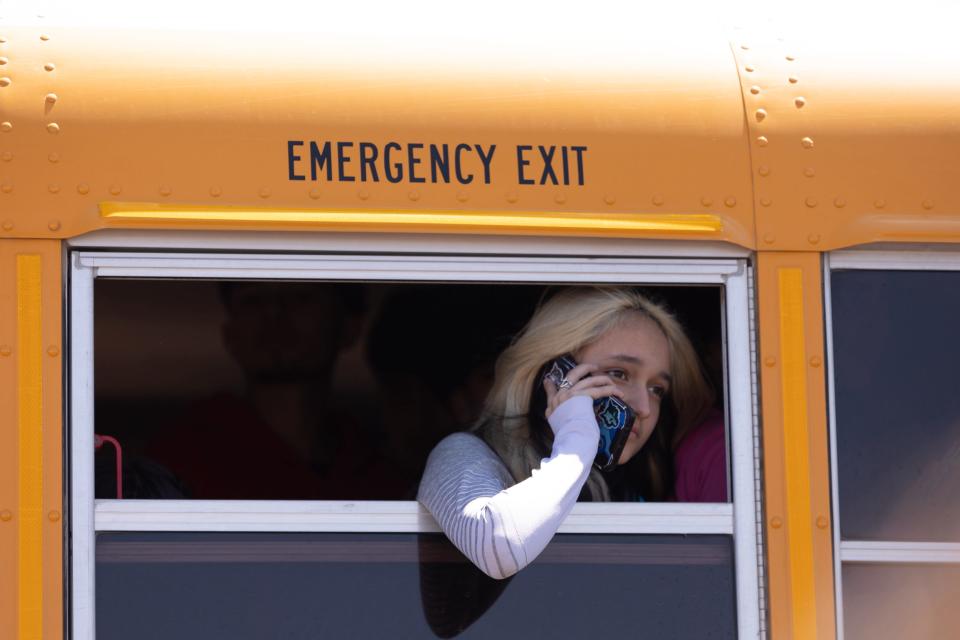 A student in a bus from Mountain View High School talked to a loved one after a threat in the Clint ISD area, Friday, April 26. The students were being bused to a reunifcation site with their parents.