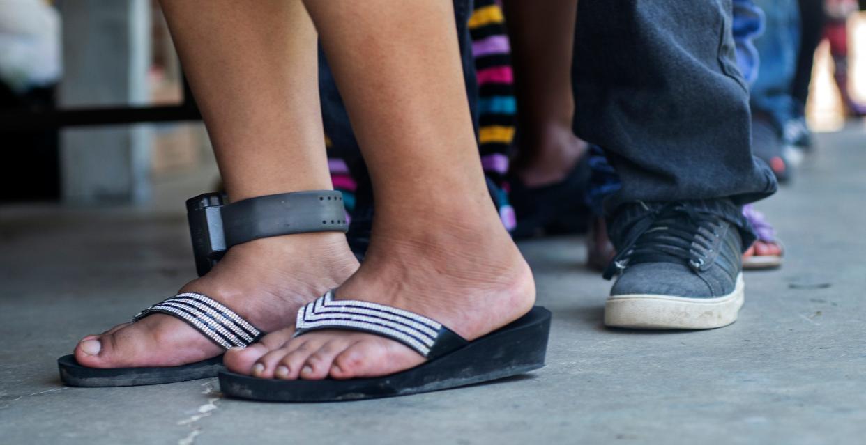 Adelaida Gabriel, of Forest, still wearing an ankle bracelet on from the August 2019 ICE raids, goes through the line for a school supply distribution with her son at Trinity Mission Center in Forest, Miss., Saturday, July 11, 2020.