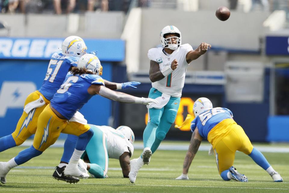 Miami Dolphins quarterback Tua Tagovailoa throws under pressure from Chargers rushers.