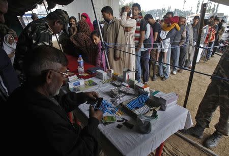 Flood victims stand in queue at a free medical camp setup by Indian security forces in Srinagar September 14, 2014. REUTERS/Danish Ismail