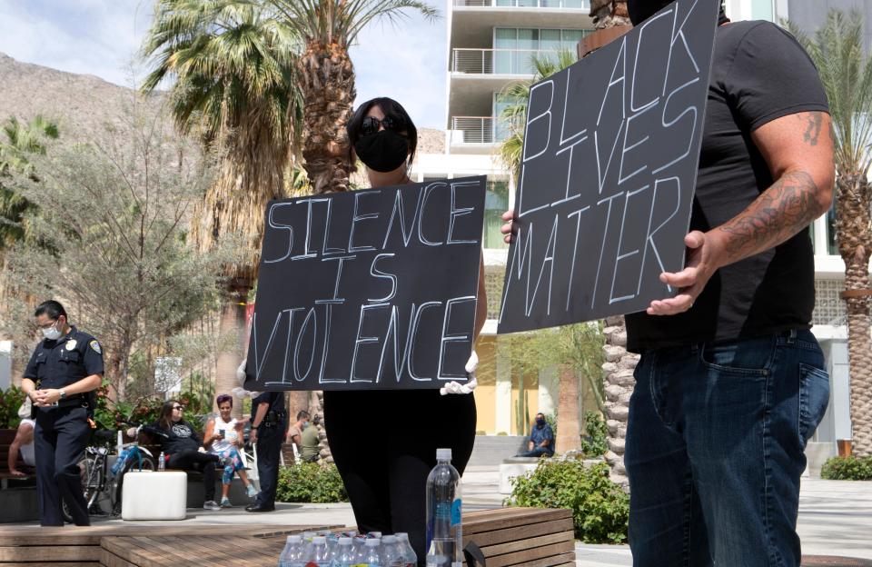 Emily and Paul Harrison, both of Palm Springs hold Black Lives Matter signs in downtown Palm Springs, Calif., on Monday, June 1, 2020. 