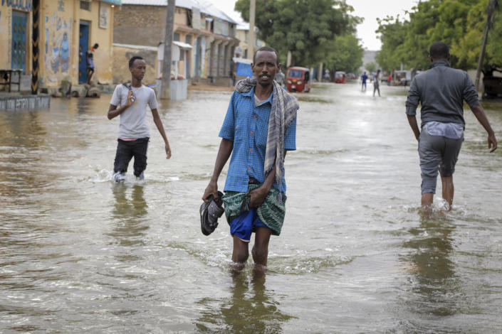 Men walk through floodwaters on a street in the town of Beledweyne, in Somalia, Monday, May 15, 2023. Estimates from the UN Office for the Coordination of Humanitarian Affairs are that 460,000 people have been affected by flooding caused by heavy rains since mid-March. (AP Photo)