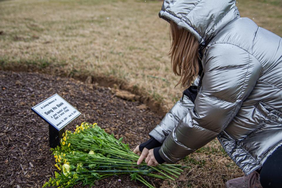 Katarina Meinzinger, a Washington D.C. resident, pays her respects at the nearby George Mason University Baseball Sang Ho Baek Memorial,