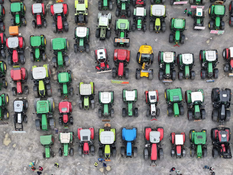 Farmers have parked their tractors in a square in front of the Oberschwabenhalle. In response to the federal government's austerity plans, the farmers' association has called for a week of action with rallies on 8 January. Felix Kästle/dpa
