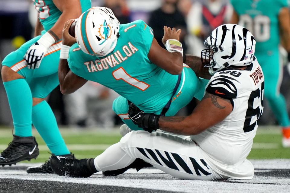 Cincinnati Bengals defensive tackle Josh Tupou (68) sacks Miami Dolphins quarterback Tua Tagovailoa (1) in the second quarter at Paycor Stadium in Cincinnati. Tagovailoa sustained a head injury on the play and left the game.