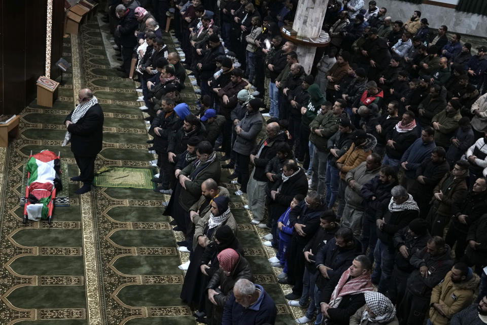 Palestinian mourners pray next to the body of Hamza al-Ashqar, 17, during his funeral in the Askar refugee camp near the West Bank city of Nablus, Tuesday, Feb. 7, 2023. The Palestinian Health Ministry says that Israeli troops killed the teenager, who died of a gunshot wound to the head during a raid. The Israeli military said its troops came under attack during a raid in Nablus, where soldiers fired at an armed Palestinian who shot at them. (AP Photo/Majdi Mohammed)