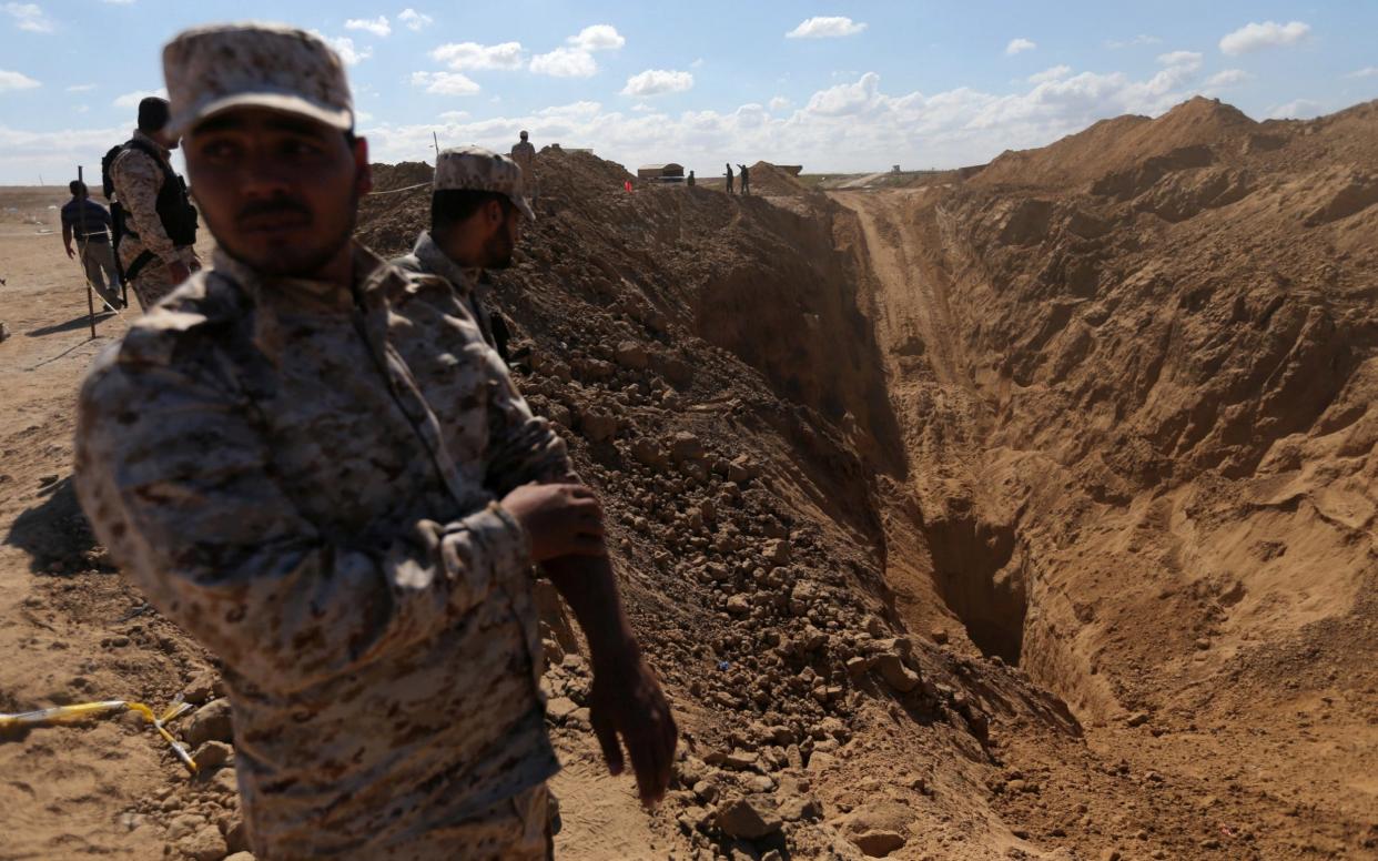 Members of Palestinian security forces loyal to Hamas stand while searching for missing or dead militants after Israel blew up a cross-border tunnel, - REUTERS