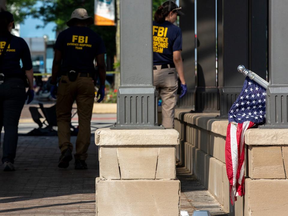 Backs of FBI agents next to US flag