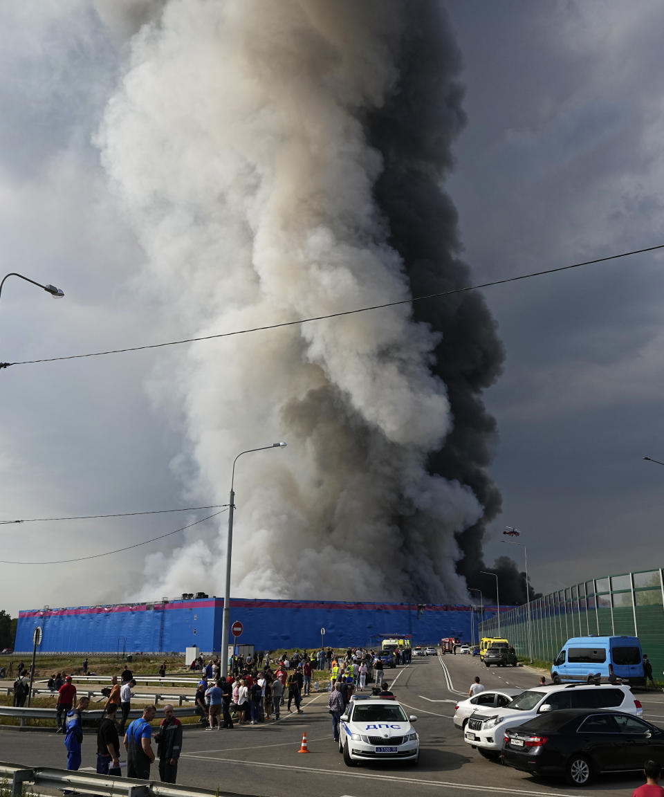 Smoke rises over a burning warehouse of the online retailer Ozon in Istra Municipal District, northwest Moscow Region, Russia, Wednesday, Aug. 3, 2022. The fire, which erupted at the warehouse belonging to Russia's leading online retailer Ozon, has covered the area of 50,000 square meters and injured 11 people, two of whom were hospitalized. (AP Photo/Alexander Zemlianichenko)