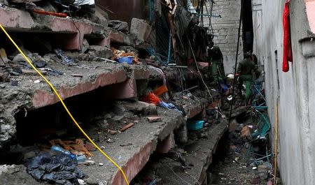 Rescue workers search for residents feared trapped in the rubble of a six-storey building that collapsed after days of heavy rain in Nairobi, Kenya, May 1, 2016. REUTERS/Thomas Mukoya