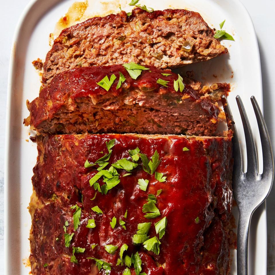 meatloaf topped with sauce and fresh herbs