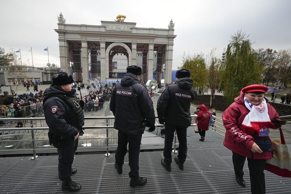 Police guard an area as visitors lineup to attend opening of the International exhibition "Russia" at VDNKh (The Exhibition of Achievements of National Economy) in Moscow, Russia, Saturday, Nov. 4, 2023. The vast show was put together under a decree from President Vladimir Putin and is seen as encouraging patriotism in the runup to the presidential election in March. (AP Photo/Alexander Zemlianichenko)