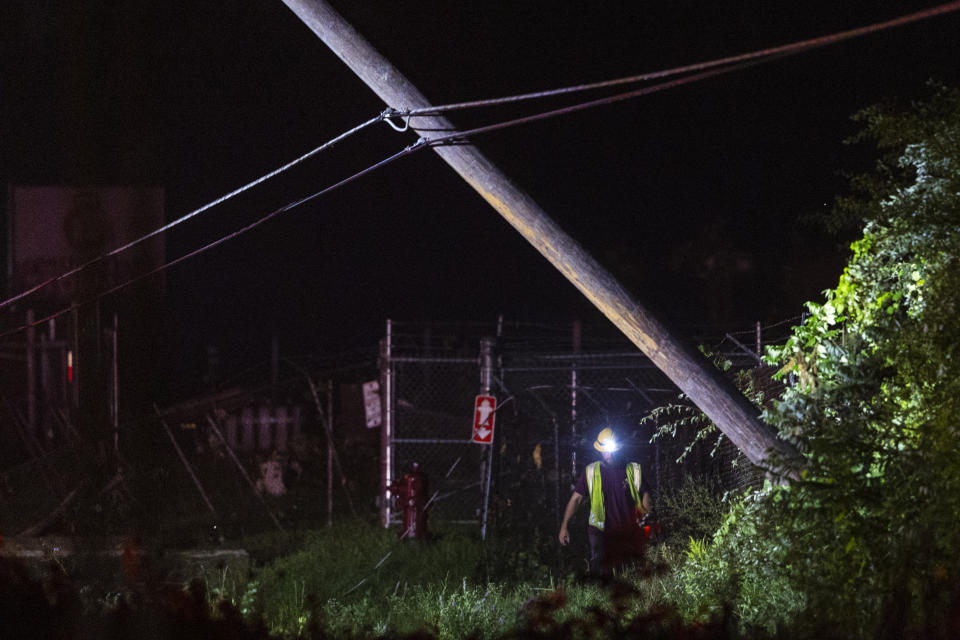 Emergency crews assess damage after a strong storm passed in Kent County, Michigan on Thursday, Aug. 24, 2023. A strong storm powered by winds up to 75 mph has downed trees and power lines across Michigan, torn roofs off buildings and left hundreds of thousands of customers without power. (Joel Bissell/Kalamazoo Gazette via AP)