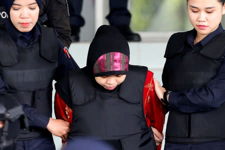FILE PHOTO: Indonesian Siti Aisyah, who is on trial for the killing of Kim Jong Nam, the estranged half-brother of North Korea's leader, is escorted as she leaves the Shah Alam High Court on the outskirts of Kuala Lumpur, Malaysia August 16, 2018. REUTERS/Lai Seng Sin/File photo