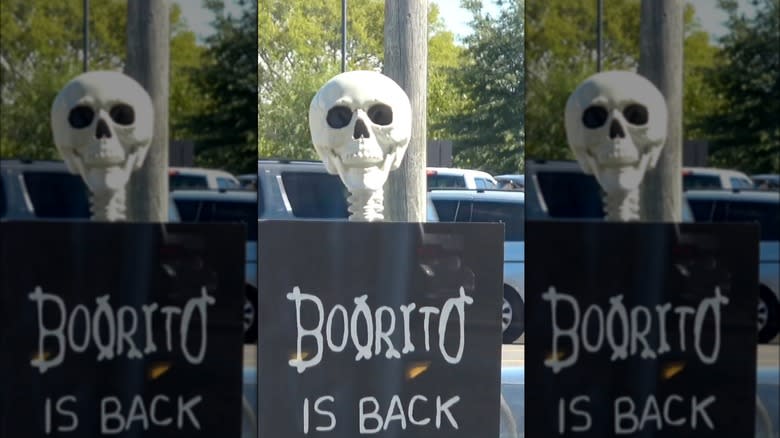 skeleton holding a Boorito sign
