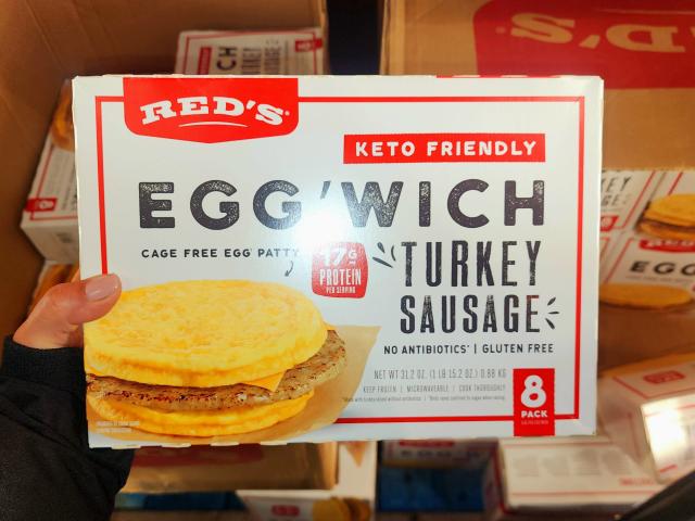 The writer holds a box of Red's turkey-sausage Egg'wiches
