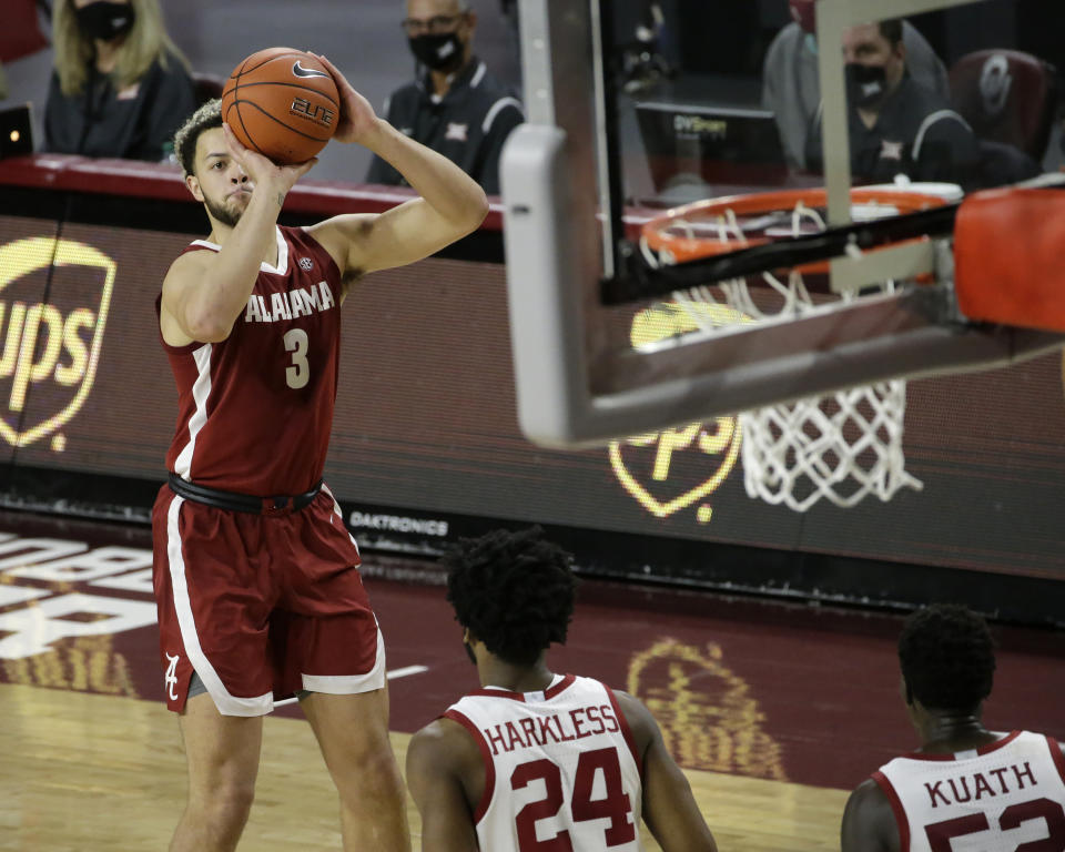 Alabama's Alex Reese (3) takes a shot against Oklahoma's Elijah Harkless (24) and Kur Kuath (52) during the first half of an NCAA college basketball game in Norman, Okla., Saturday, Jan. 30, 2021. (AP Photo/Garett Fisbeck)