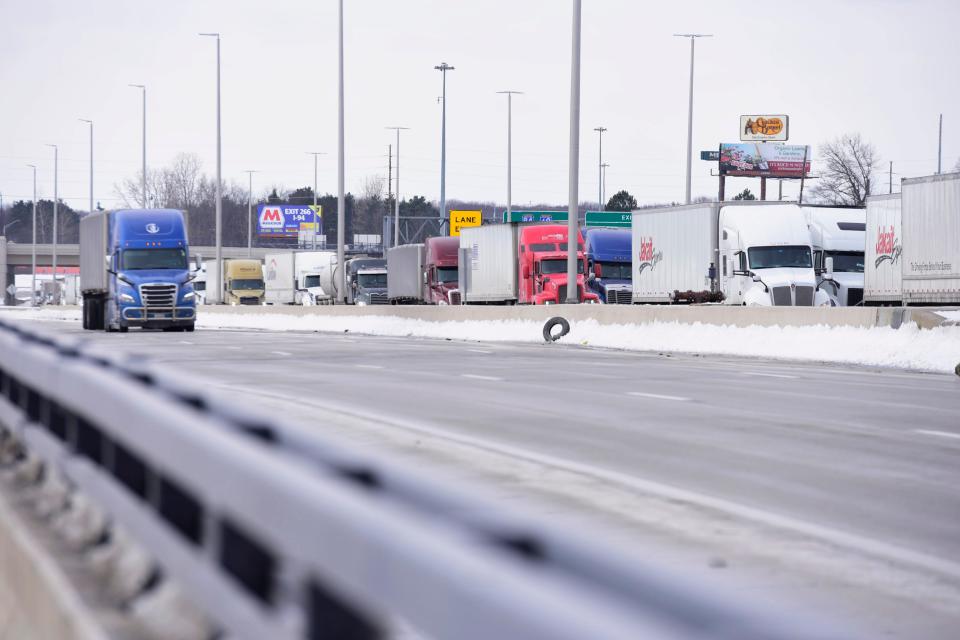 Following a partial closure of the Ambassador Bridge, tractor-trailers line up on the on ramp to the Blue Water Bridge on Interstate-94 to Canada in Port Huron on Tuesday, Feb. 8, 2022.