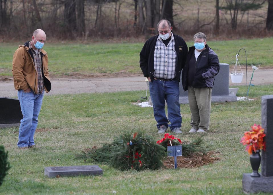 Frank "Keith" Malinowski, left, visits the grave of his sister, Jamie Malinowski, with parents Frank and Jody Malinowski in Doylestown, Ohio.