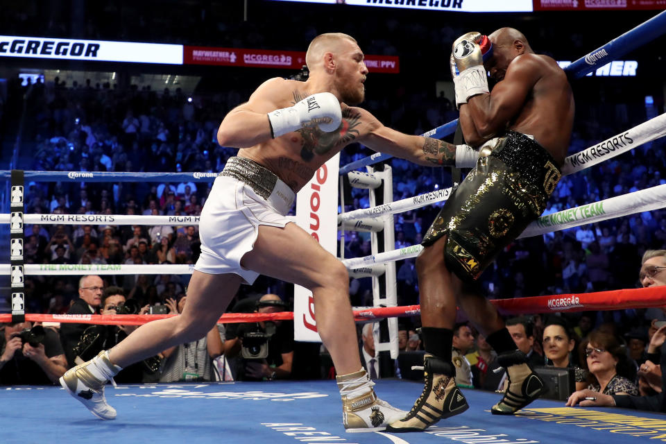 LAS VEGAS, NV - AUGUST 26:  (L-R) Conor McGregor throws a punch at Floyd Mayweather Jr. during their super welterweight boxing match on August 26, 2017 at T-Mobile Arena in Las Vegas, Nevada.  (Photo by Christian Petersen/Getty Images)